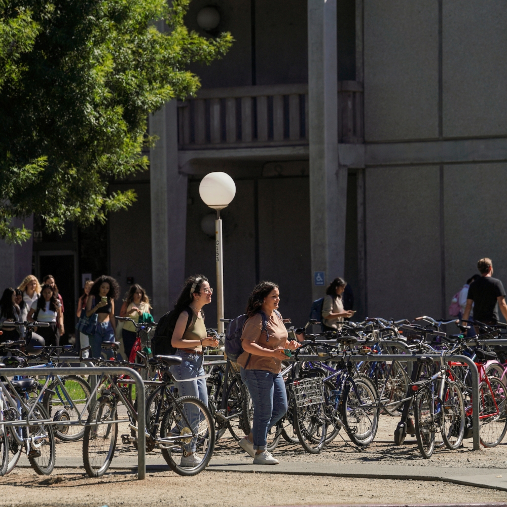 Students lock up their bikes at a bike rack in front of Olson Hall at UC Davis.